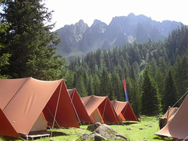 Zelte vor einer Bergkulisse.